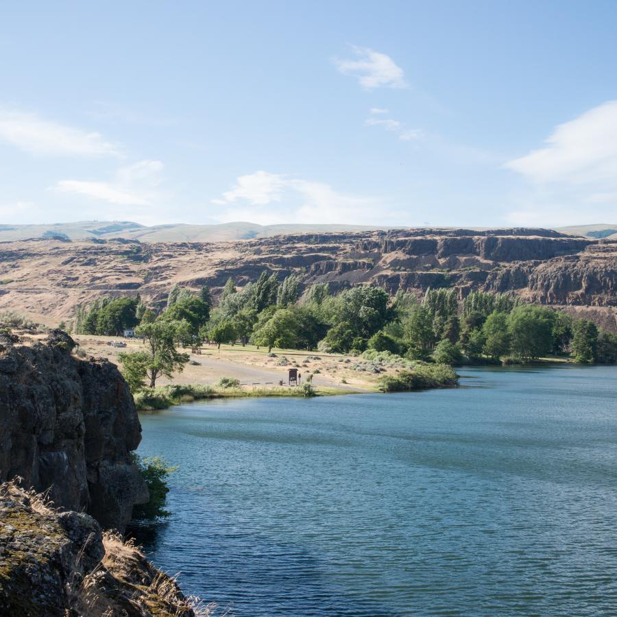 Overlook viewing a majestic bluff with blue river below, orange bluffs and green pines