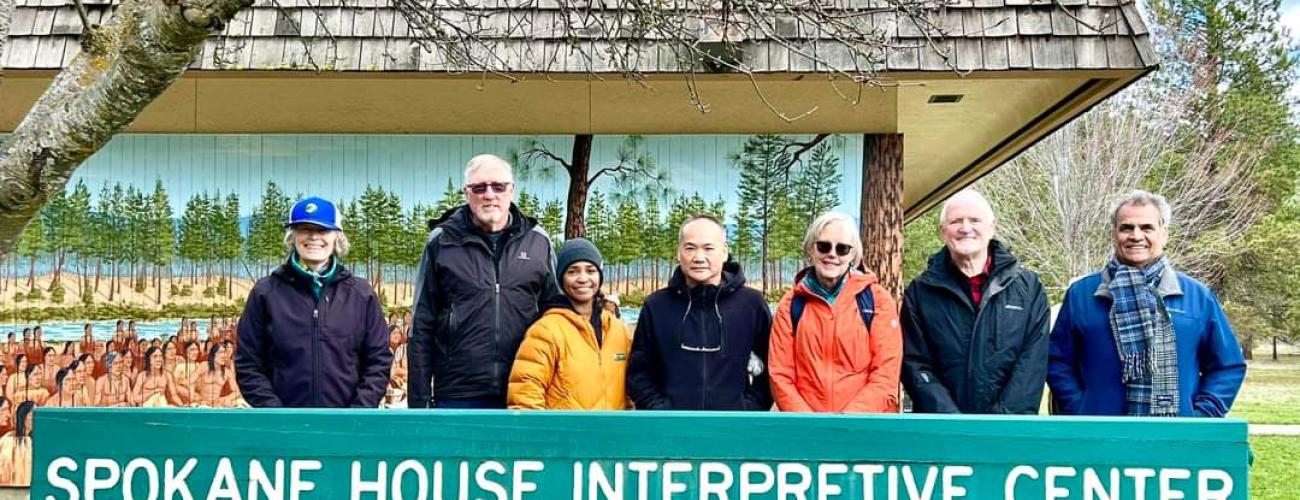 The seven members of the Washington State Parks Recreation stand in front of the Spokane House Interpretive Center at Riverside State Park.  They are wearing winter clothing.
