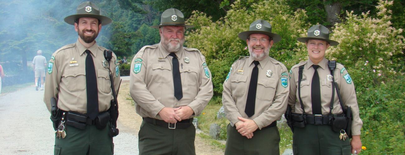 Four park rangers in front of trees