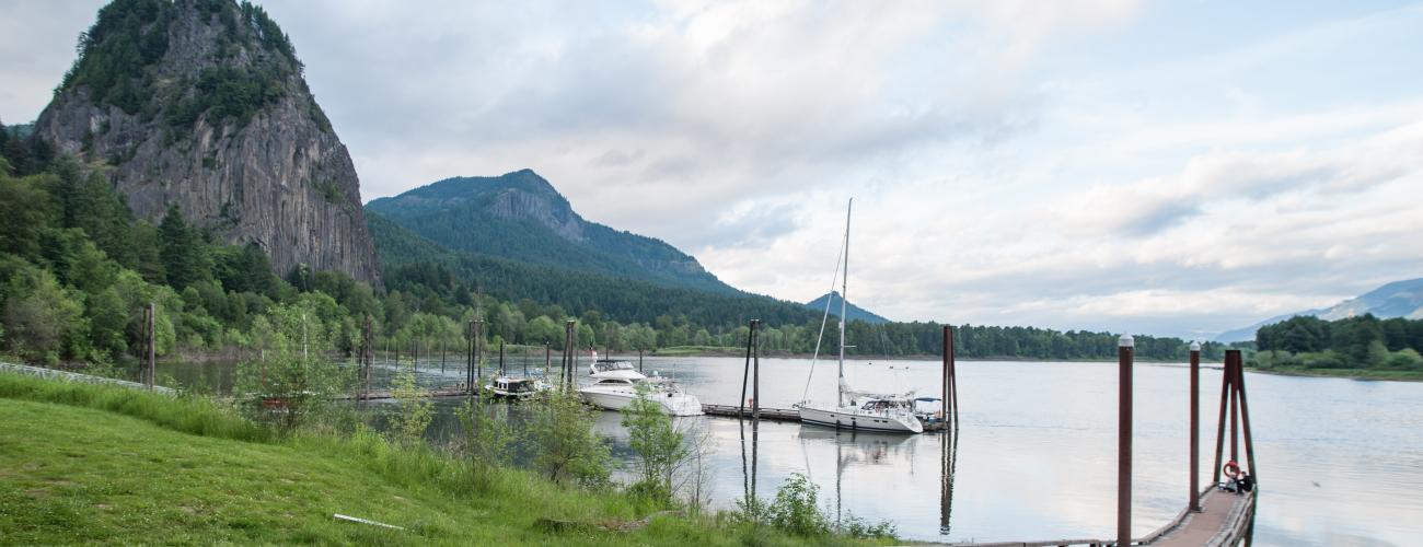 cliff rising above water with boats