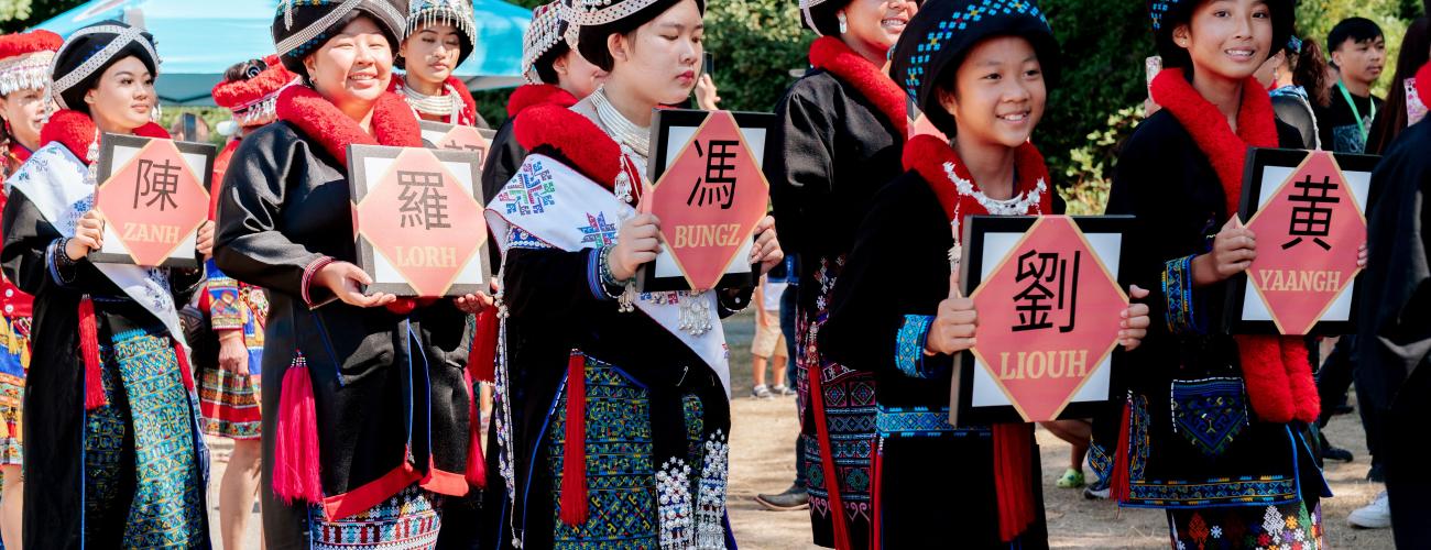 A group of Iu Mien women march in a community parade in traditional dress.