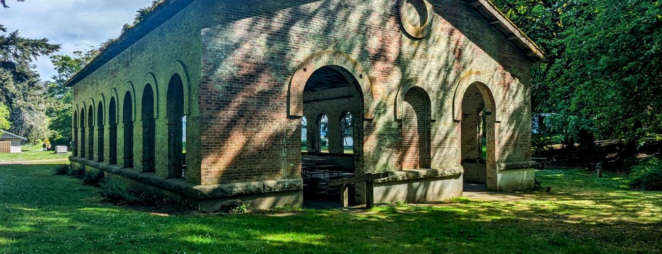 A large brick building in dappled sunlight.