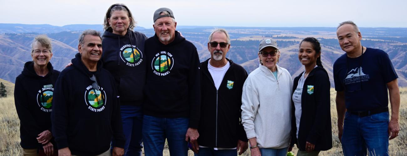 Photo of Commissioners at Puffer Butte in Spring Fields State Park. Left to right Commissioner Holly Williams, Commissioner Ali Raad, Director Diana Dupuis, Commissioner Ken Bounds, Commissioner Laurie Connelly, Commissioner Sophia Danenberg, Commissioner Michael Latimer.