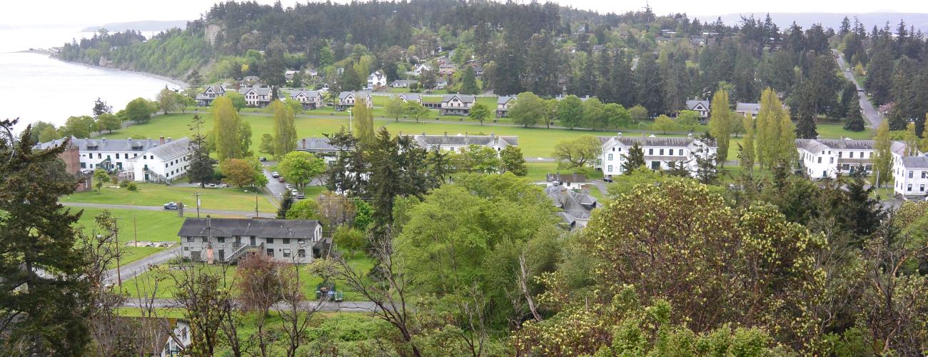 A view from a hill of a military fort, a beach and green trees