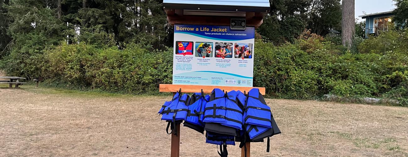 A life jacket loaner stand near a water access point