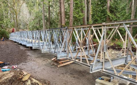 A bridge, partially assembled, on the ground.