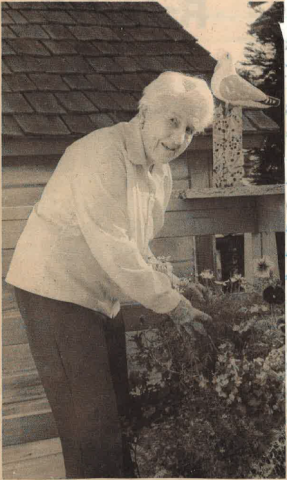 A sepia toned photo of an older woman in the garden