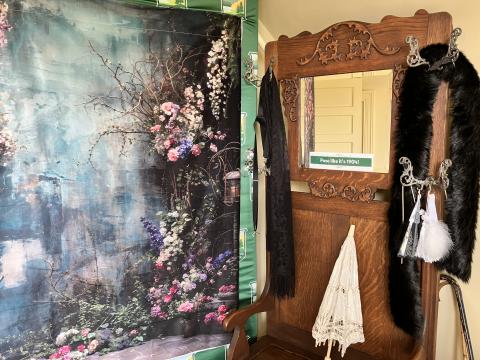 Selfie booth in historic home with backdrop, props (umbrella, stole, hat) and mirror