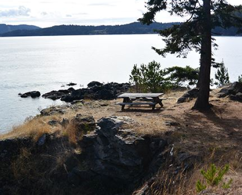 Picnic table near bluff with the ocean and islands in the background