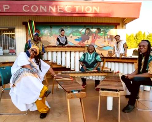 A group of African musician sitting around their musical instruments.