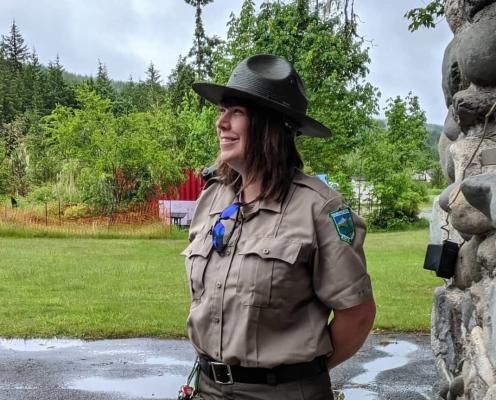 A female park ranger with shoulder length brown hair in uniform
