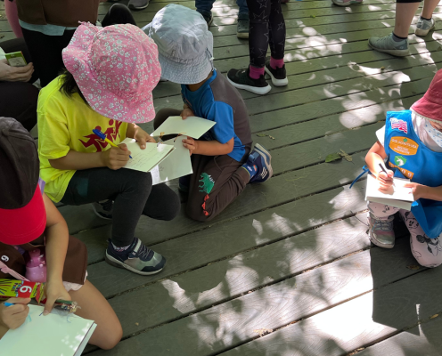 Girl Scouts circled up taking notes while they learn from our interpretive rangers