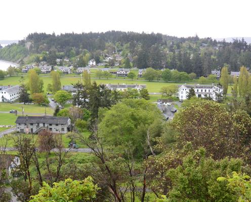 A view from a hill of a military fort, a beach and green trees