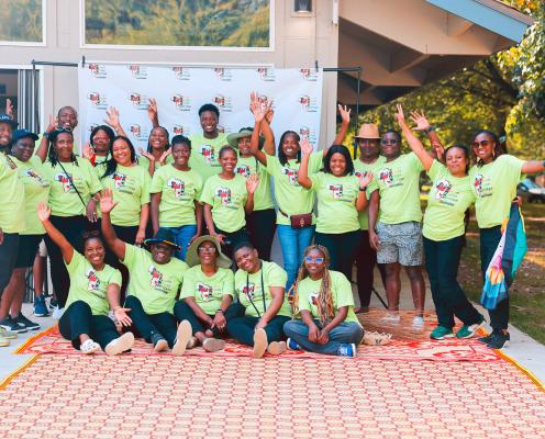 A group of African people from Ubuntu Nerudo African Heritage wearing green t-shirts and posing for a picture