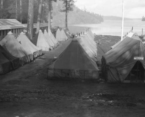 canvas tents in orderly rows near a beach