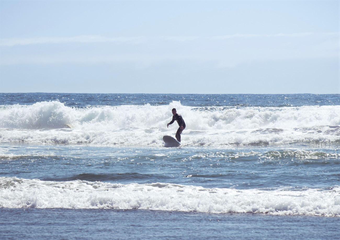 A surfer rides a wave at Westport Light State Park