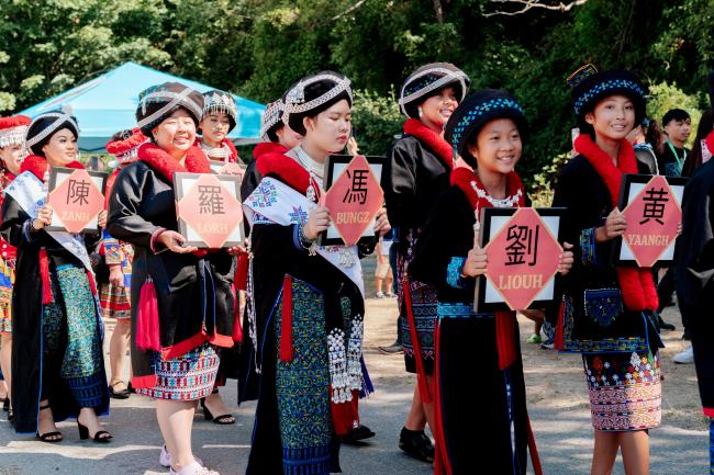 A group of Iu Mien women march in a community parade in traditional dress.