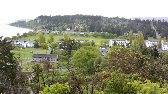 A view from a hill of a military fort, a beach and green trees