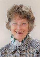 Headshot of Commissioner Holly Williams wearing a plaid jacket and a blue and white scarf.