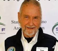 Man standing in front of a step and repeat background