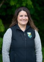 Washington State Parks Human Relations Director Amber Erdahl poses in front of evergreen trees.