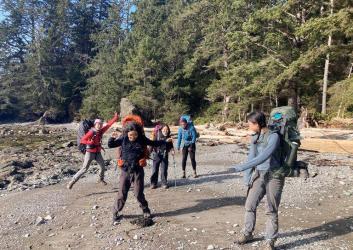 Members of the Emerging Leaders Program smile on the beach during a group backpacking trip
