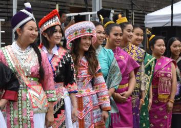 A group of Laotian, Hmong and Khmu women pose in traditional dress.