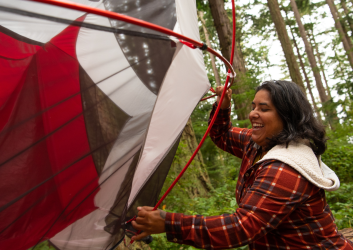 person trying to set up tent at a campsite