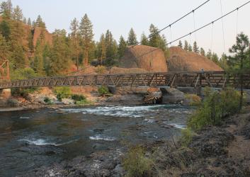 suspension bridge over river surrounded by rocky cliffs