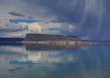 large rocky cliffs rising above calm lake water