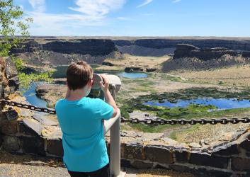 Kid looking to the binoculars at the Dry Falls Visitor Center
