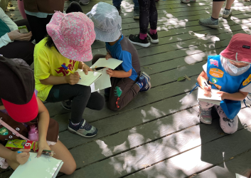 Girl Scouts circled up taking notes while they learn from our interpretive rangers