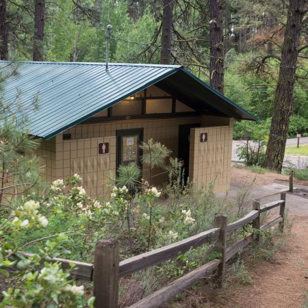 building restroom facility surrounded by flowers and fenced walkway