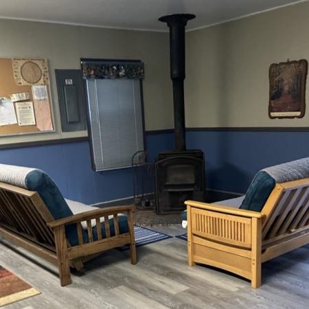 lounge area with two couches and wood stove in the corner