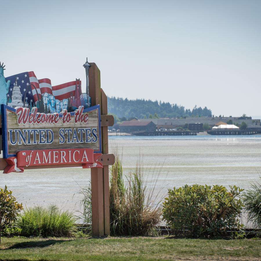 Wooden Welcome to America sign by the ocean as you pull up to the border crossing