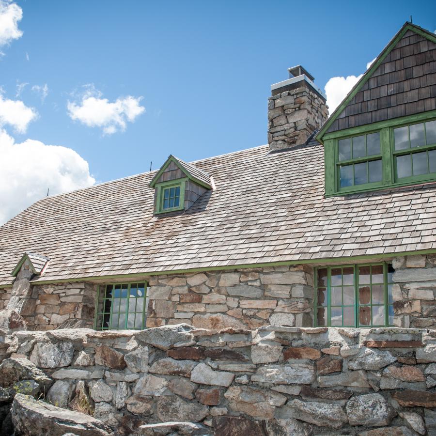A close up view of the Vista House made out of stone behind a short stone wall.