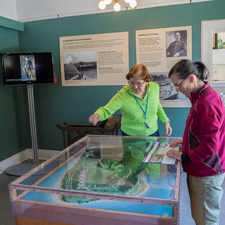 People looking at the miniature model of Fort Casey State Park in the Interpretative Center 