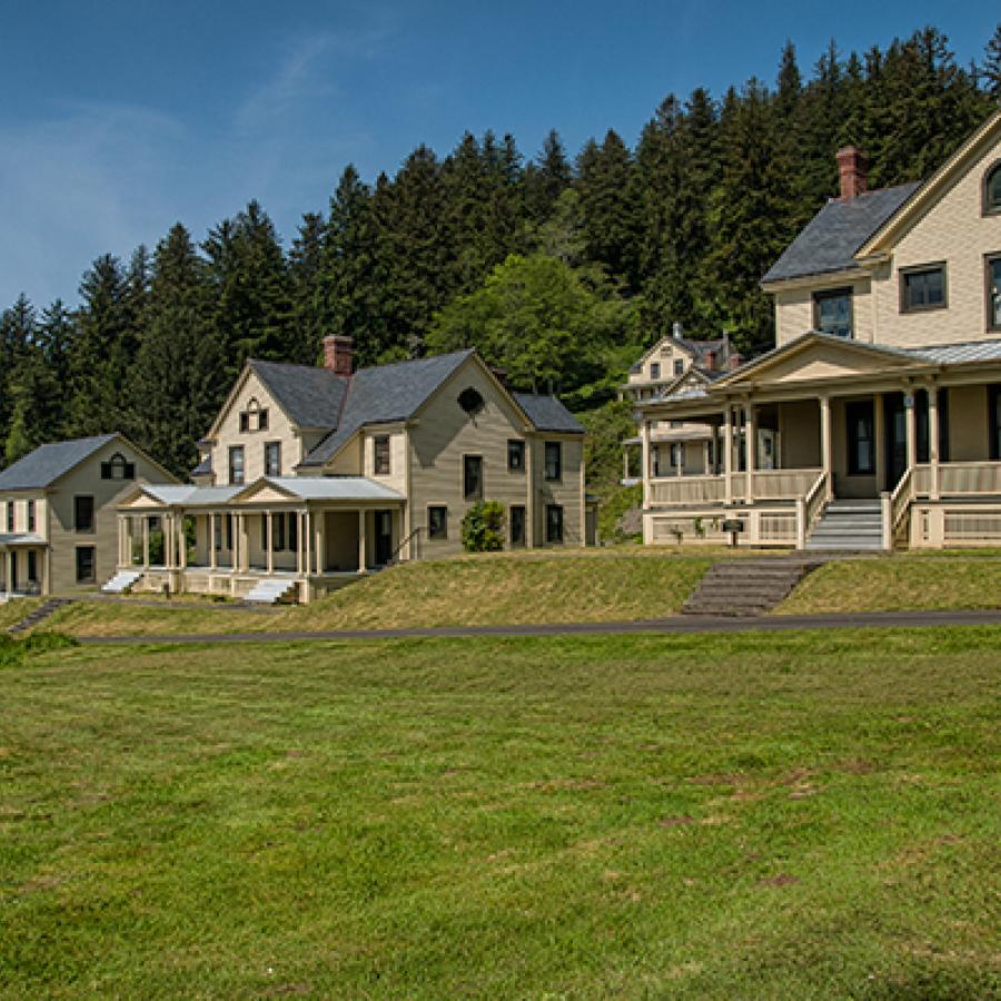 Frontal view of the vacation rentals, with a large grass field in front and trees in the background.