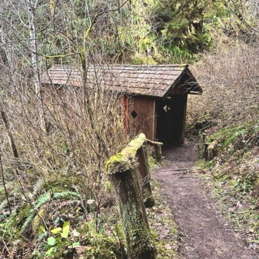 rustic wooden covered bridge along hiking trail
