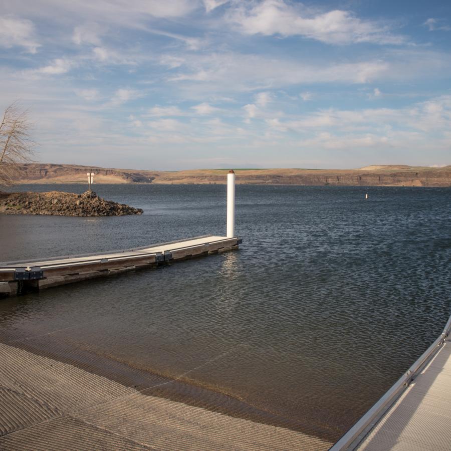 One boat launch, two docks. Slight winds on the lake and a cloudy blue sky. 