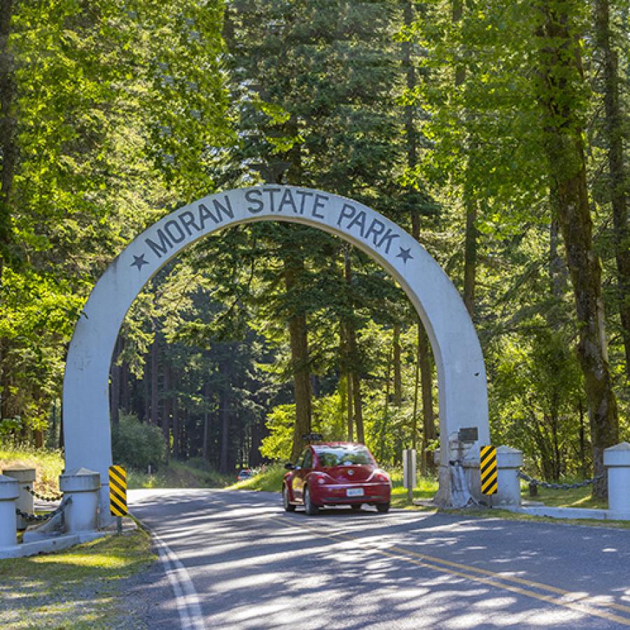 entry way arch with name of Moran Park written across -with car passing under