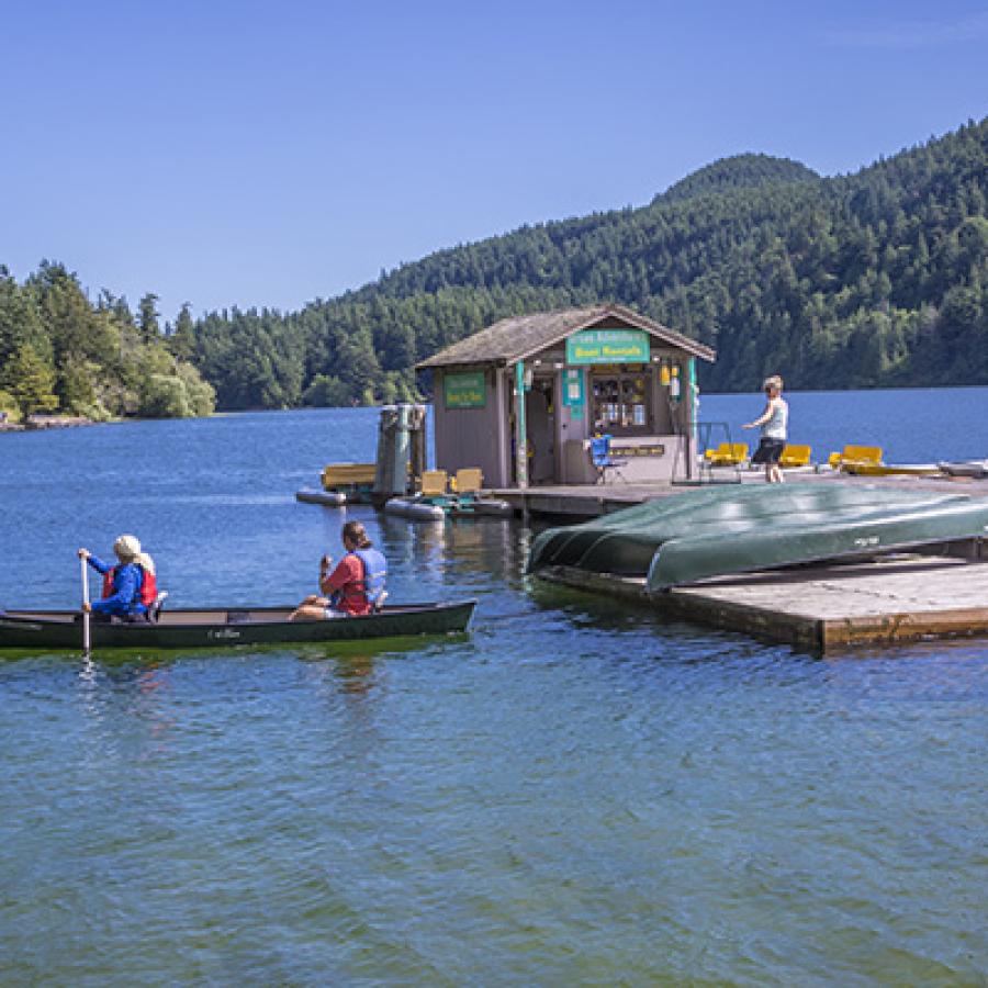 Boat house and dock with people renting canoes and kayaks