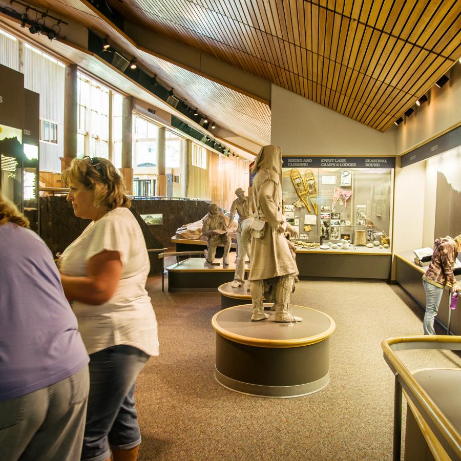 visitors at a display  with statue of Cowlitz Indian woman in the background