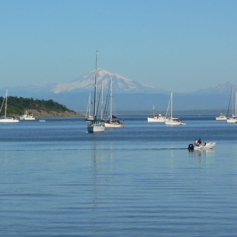 expansive view of island waterway many boats anchored and Mountain Baker in the distance