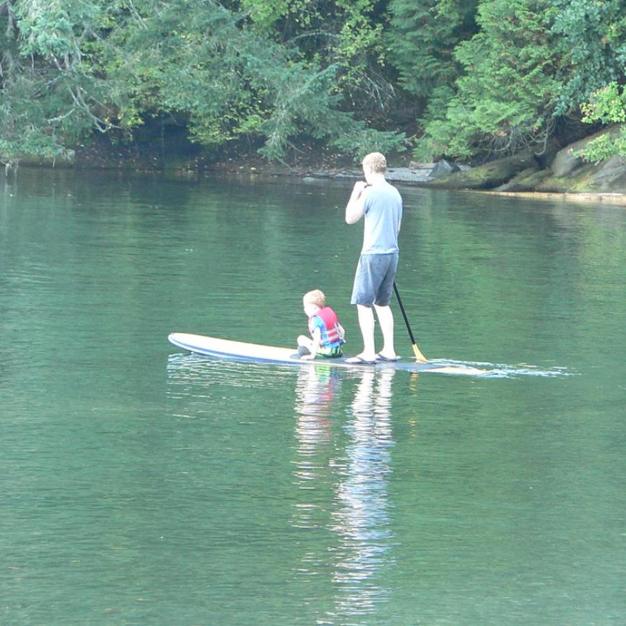 Paddle boarder with small child sitting in front