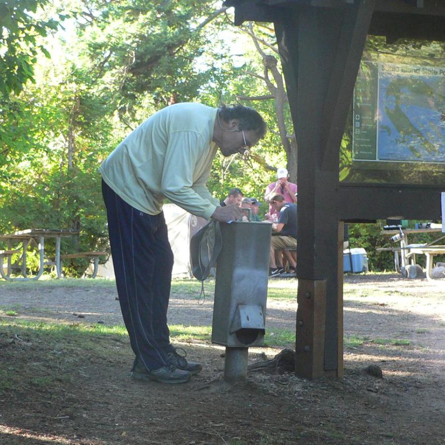 camper bent over pay station box filling out his envelope