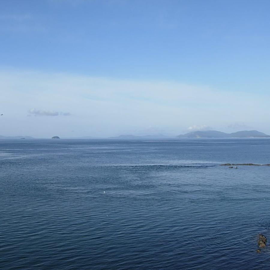 horizon of blue waters with mountains in the very far distance