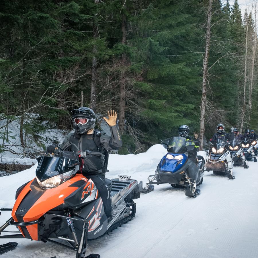 Snowmobiling among trees at Crystal Springs Sno-Park.