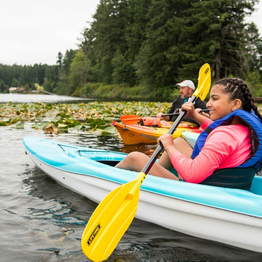 a paddle course participant kayaking alongside instructor