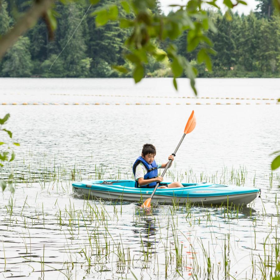 a young kayaker in the distance wearing a life jacket